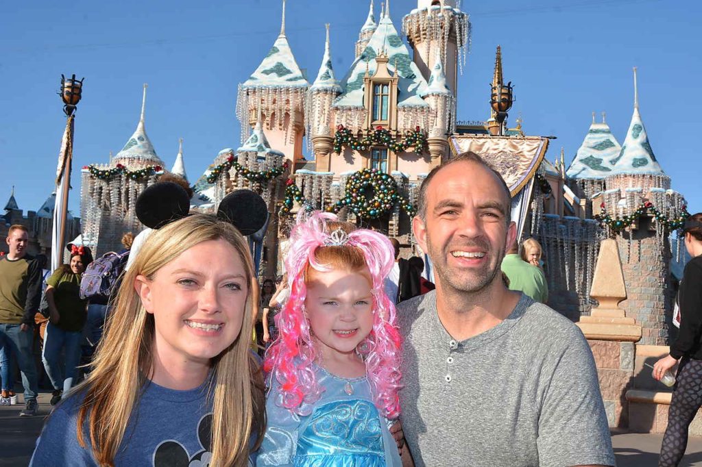 Disneyland photo pass picture of family in front of Cinderella's castle.
