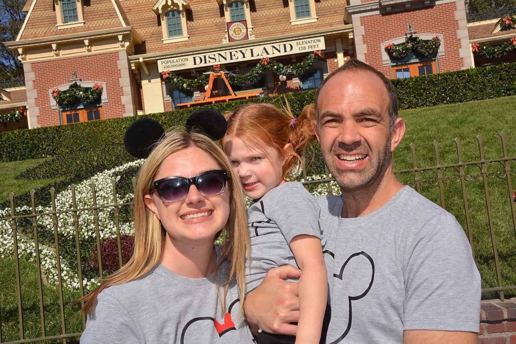family in front of Mickey Mouse lawn in Disneyland