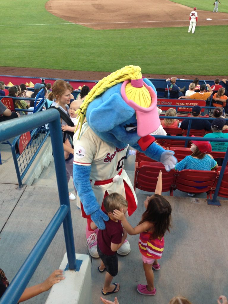 Kids hugging a mascot at a Spokane Indians baseball game. 
