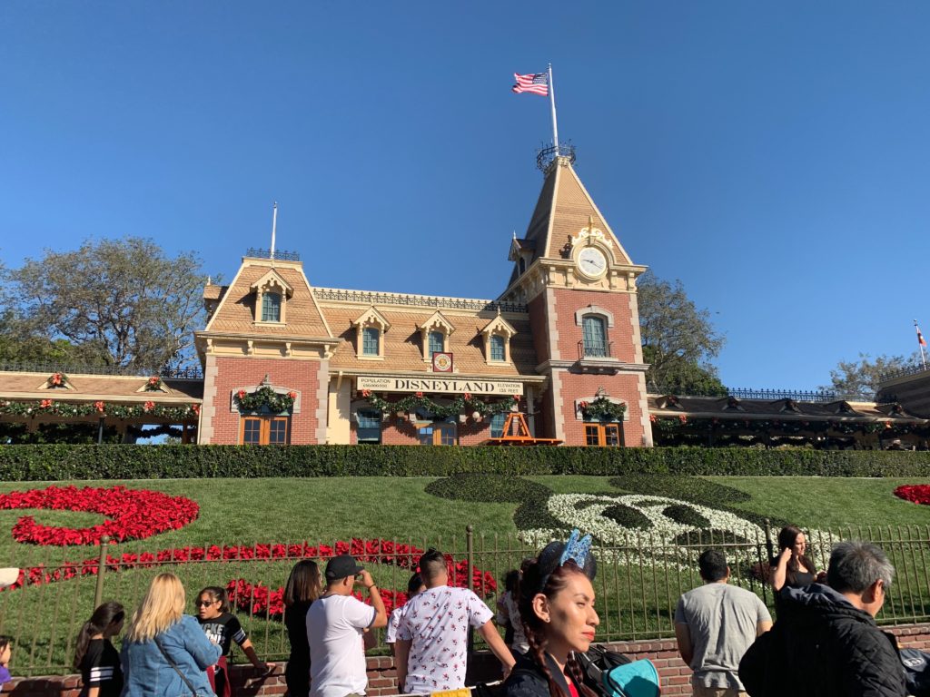 crowd taking pictures at iconic disneyland station with mickey mouse