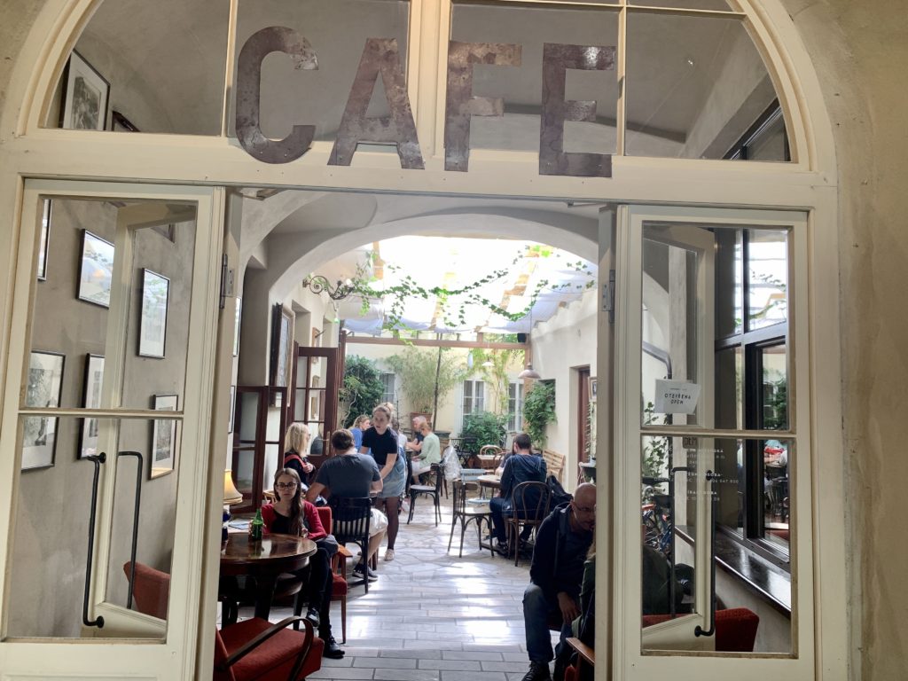 Windows and door leading to cafe with table, chairs and patrons