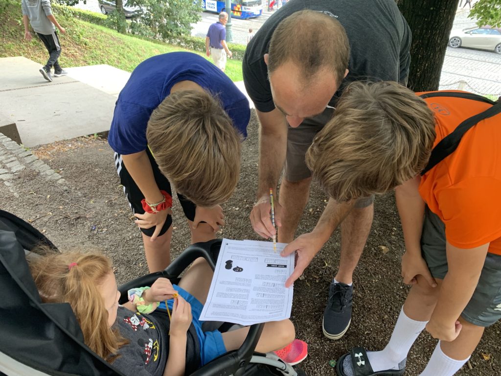 Family looking at the hints for a scavenger hunt in the Game of Prague.