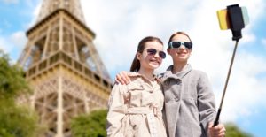 tween girls with self stick taking a photo with Eiffel Tower in background