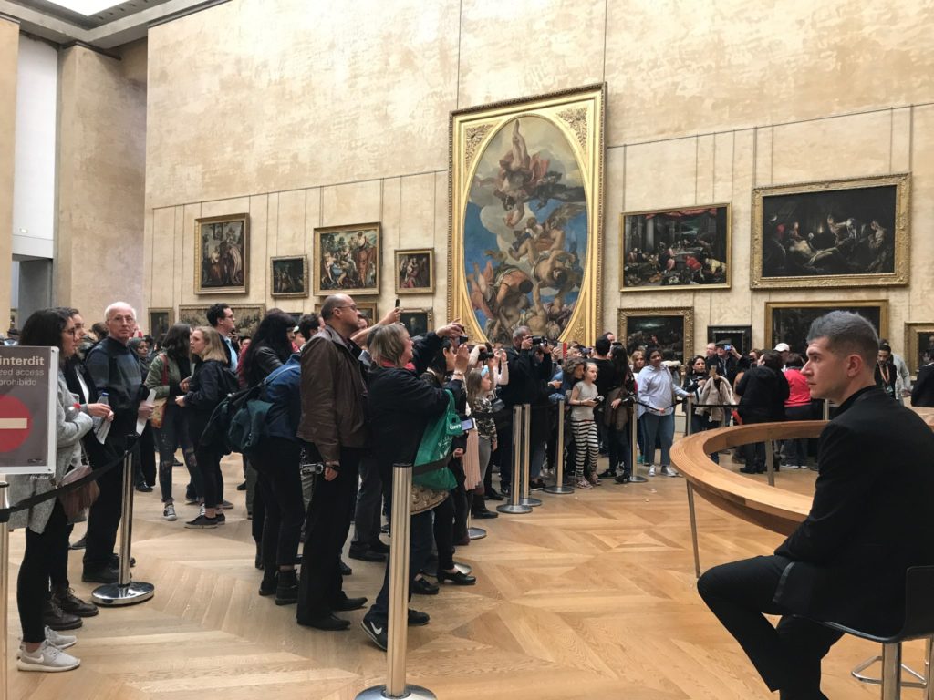 Crowd of people looking at the Mona Lisa at the Louvre in Paris