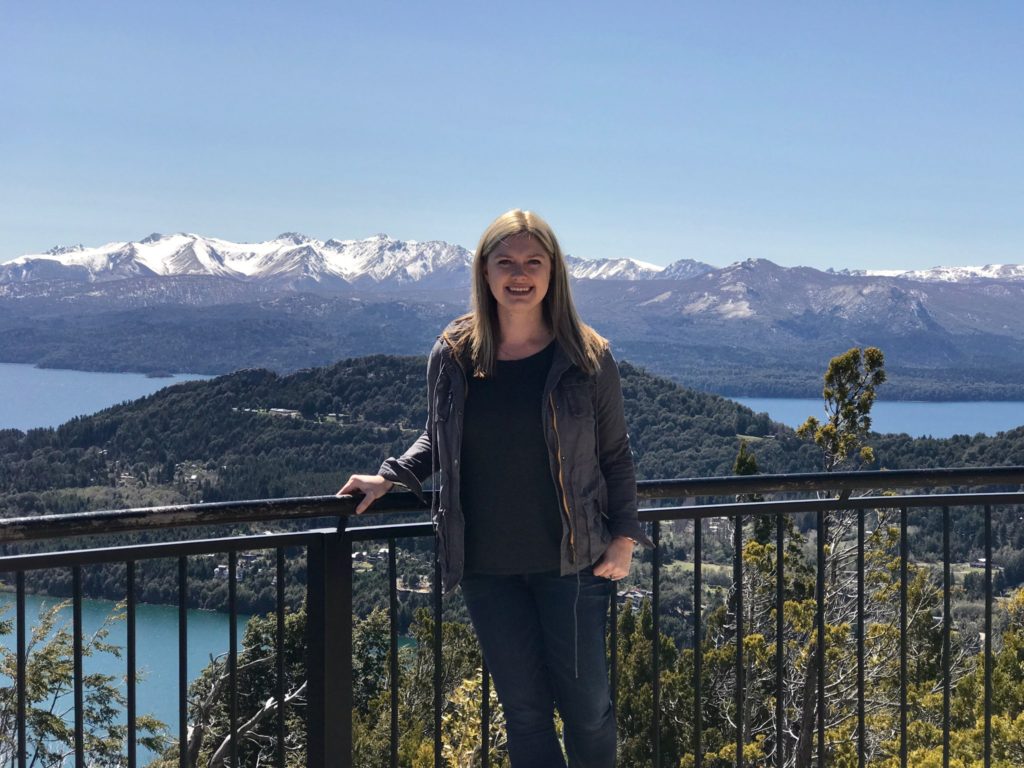 woman visiting bariloche with view of lakes and mountains in the background