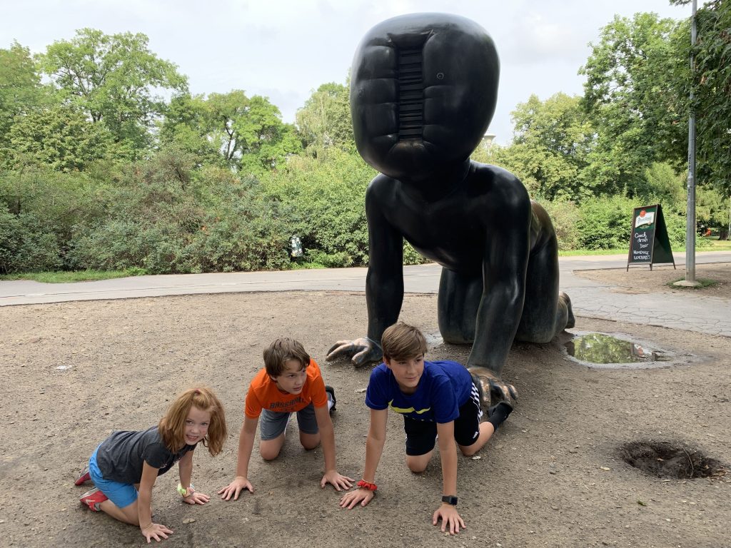 3 kids next to big baby sculpture in prague