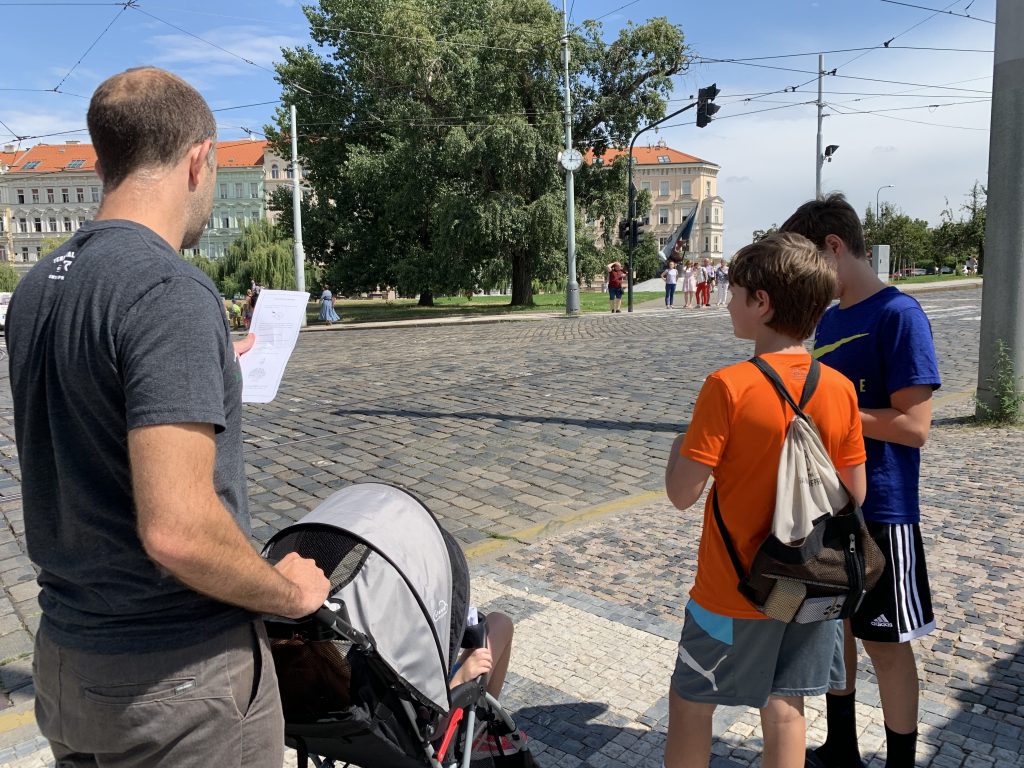 family standing next to a street playing the game of prague